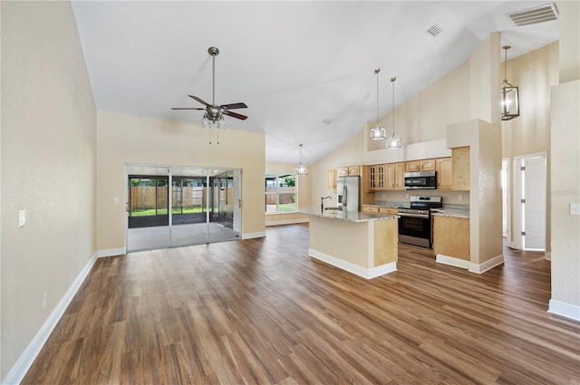 kitchen featuring stainless steel appliances, high vaulted ceiling, hanging light fixtures, and ceiling fan