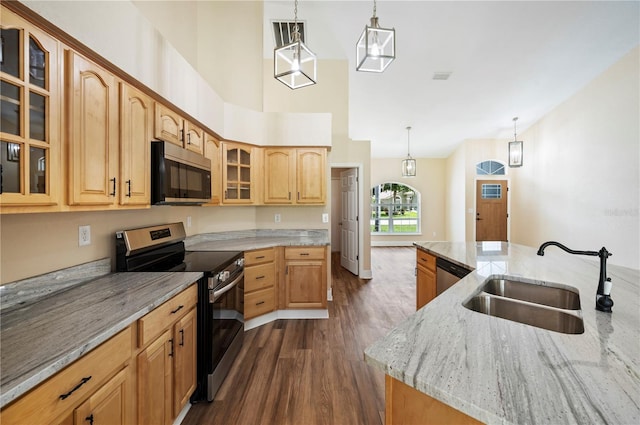 kitchen featuring appliances with stainless steel finishes, a center island with sink, hanging light fixtures, and sink