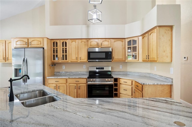 kitchen with light stone countertops, appliances with stainless steel finishes, light brown cabinets, and sink