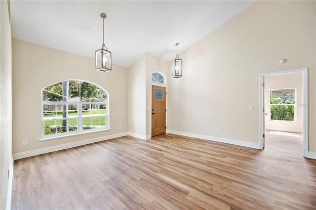 interior space featuring light wood-type flooring, high vaulted ceiling, and a wealth of natural light