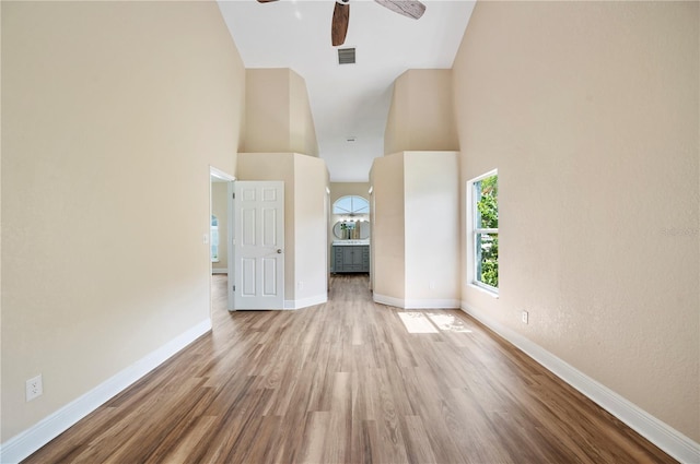 unfurnished room featuring a high ceiling, light hardwood / wood-style floors, and ceiling fan