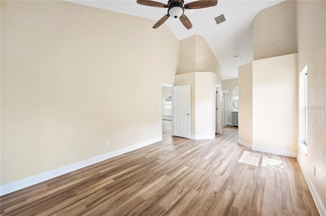 spare room featuring light hardwood / wood-style floors, high vaulted ceiling, and ceiling fan