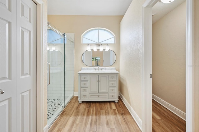 bathroom featuring a shower with door, vanity, and wood-type flooring