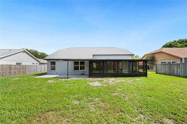 rear view of property with a lawn, a patio area, and a sunroom