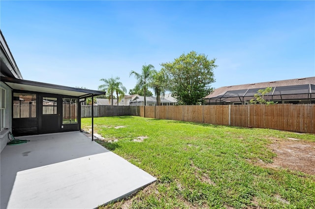 view of yard featuring a sunroom and a patio