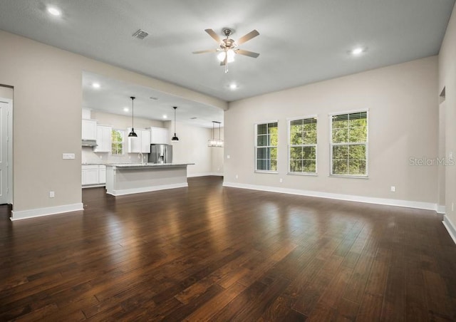 unfurnished living room featuring ceiling fan and dark hardwood / wood-style floors