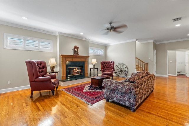 living room with ornamental molding, ceiling fan, and light hardwood / wood-style flooring