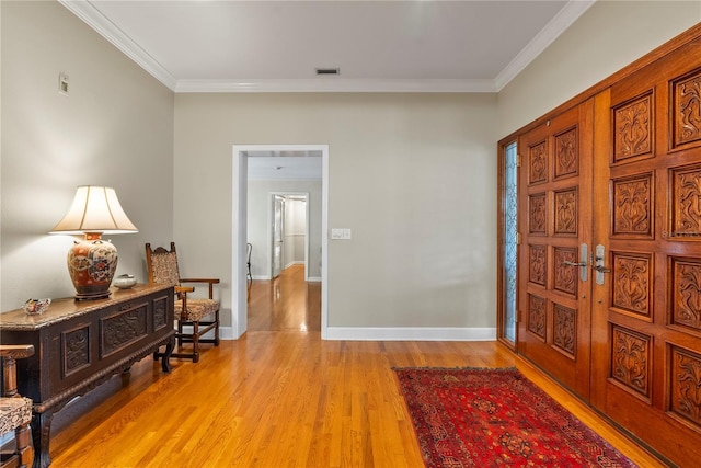 hall with crown molding and light hardwood / wood-style flooring