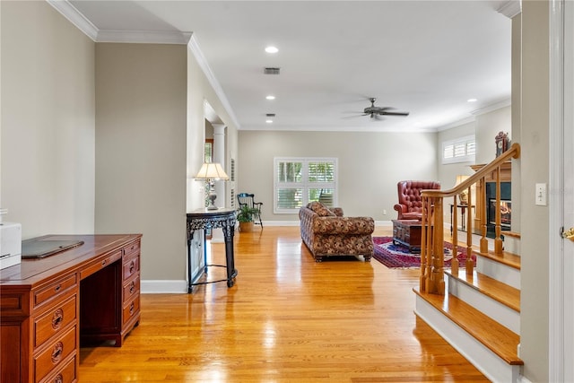 living room featuring ornamental molding, ceiling fan, and light wood-type flooring