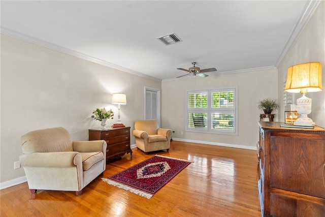 sitting room featuring hardwood / wood-style floors, crown molding, and ceiling fan