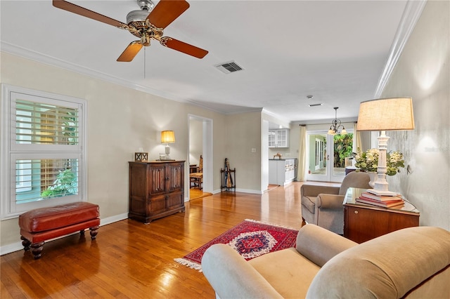 living room with hardwood / wood-style floors, plenty of natural light, and ornamental molding