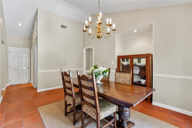 dining area with high vaulted ceiling, tile patterned floors, and a chandelier