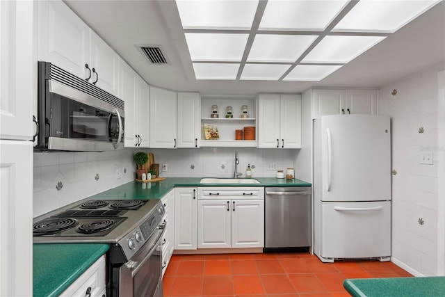 kitchen with stainless steel appliances, white cabinetry, sink, and tasteful backsplash