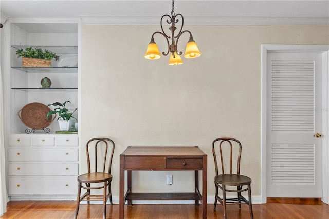 dining space featuring hardwood / wood-style floors, ornamental molding, and a chandelier