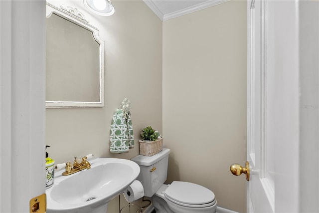 bathroom with ornamental molding, sink, and toilet