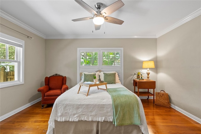 bedroom featuring hardwood / wood-style flooring, crown molding, and ceiling fan