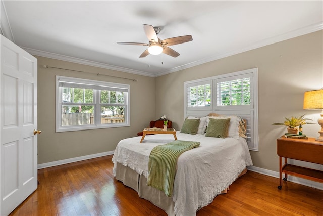 bedroom with crown molding, ceiling fan, wood-type flooring, and multiple windows