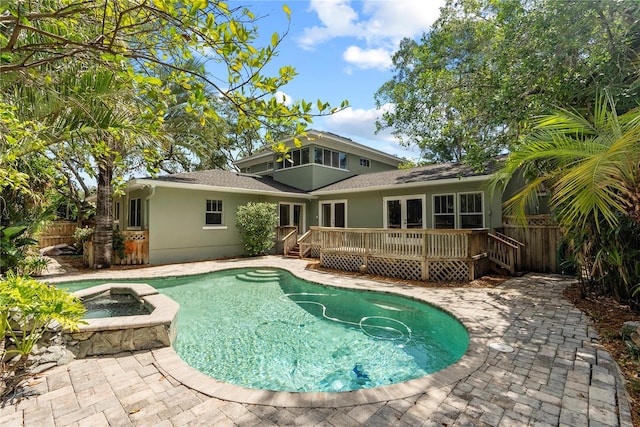 view of swimming pool featuring a wooden deck and an in ground hot tub