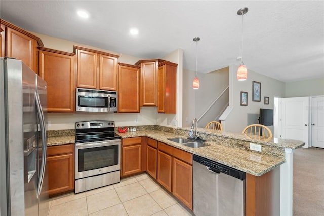 kitchen featuring decorative light fixtures, kitchen peninsula, sink, light stone countertops, and stainless steel appliances