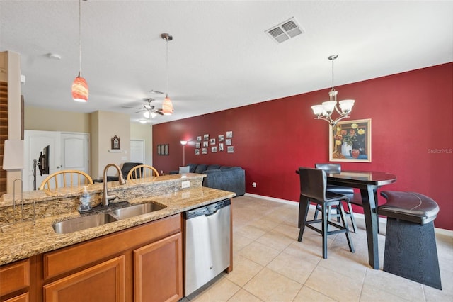 kitchen with stainless steel dishwasher, light stone counters, hanging light fixtures, and sink