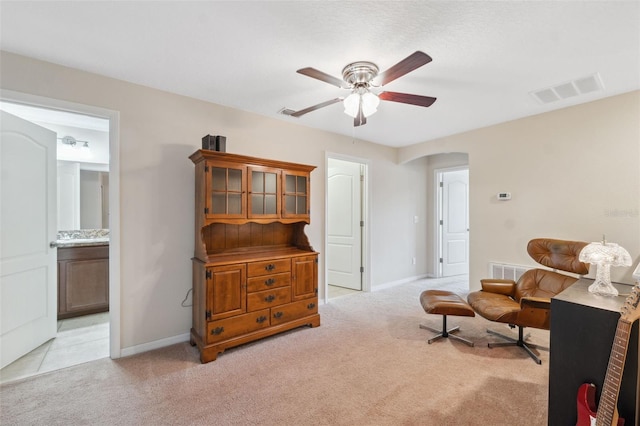 living area with ceiling fan and light colored carpet