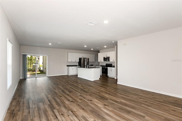 unfurnished living room with a textured ceiling and dark hardwood / wood-style floors