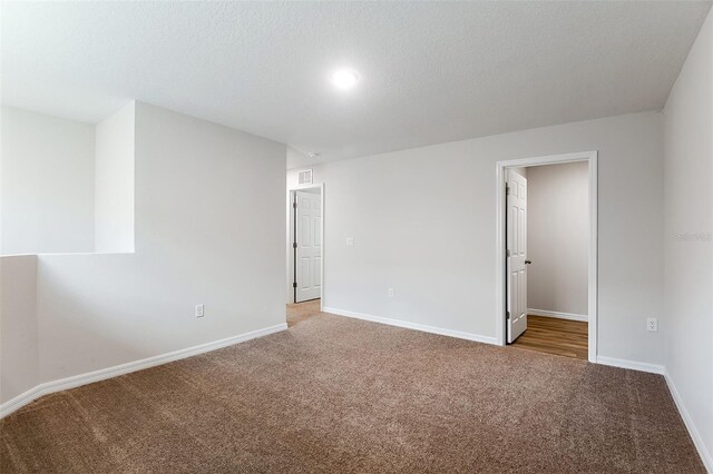 interior space featuring a textured ceiling and carpet floors