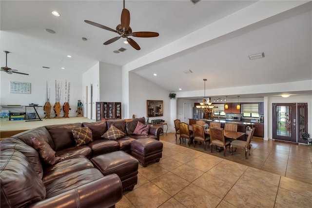 living room with lofted ceiling, light tile patterned floors, and ceiling fan with notable chandelier