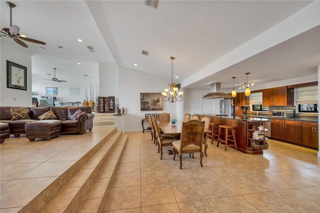 tiled dining space with ceiling fan with notable chandelier and vaulted ceiling