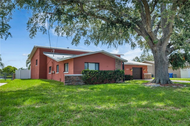 rear view of property with a garage and a lawn