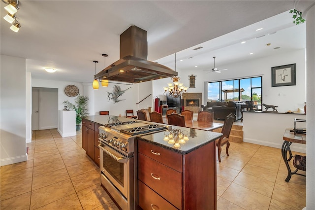 kitchen featuring island range hood, high end stainless steel range oven, light tile patterned floors, pendant lighting, and a center island