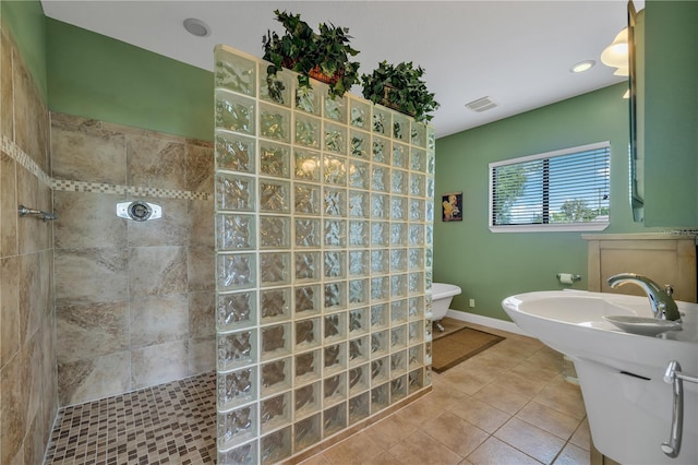 bathroom featuring toilet, tile patterned flooring, and tiled shower