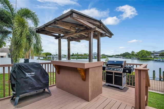 deck featuring a grill, a water view, and an outdoor bar