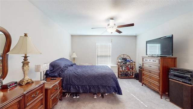 carpeted bedroom featuring a textured ceiling and ceiling fan