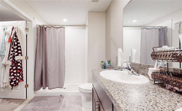 bathroom featuring vanity, curtained shower, and toilet