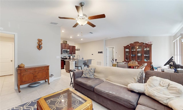 tiled living room featuring ceiling fan and sink