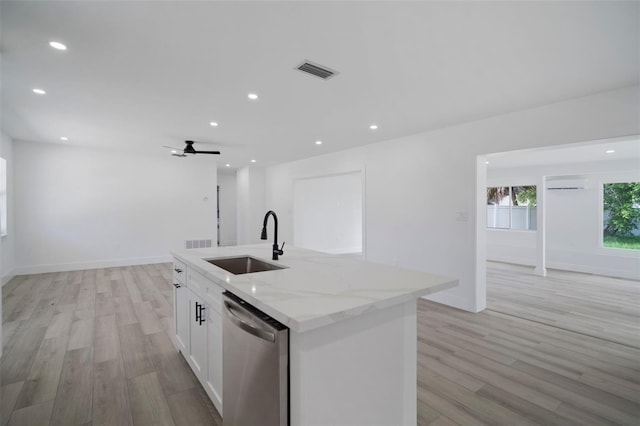 kitchen featuring light stone counters, a kitchen island with sink, sink, dishwasher, and white cabinetry