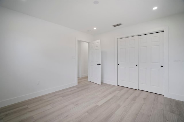 unfurnished bedroom with a closet and light wood-type flooring