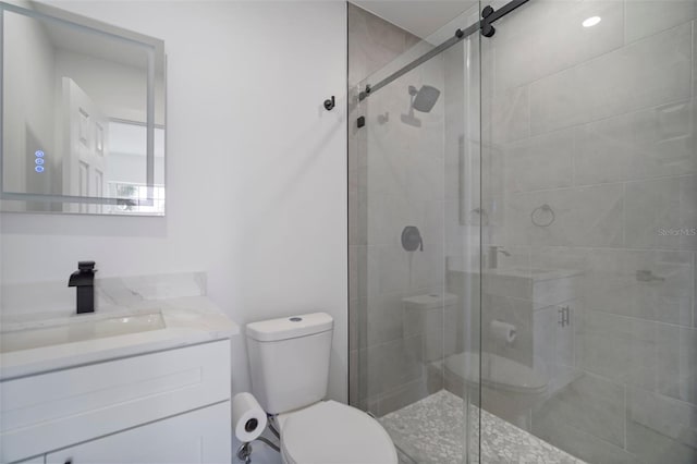 bathroom featuring vanity, toilet, and an enclosed shower