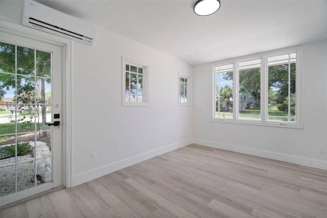 empty room with a wall unit AC and light hardwood / wood-style floors