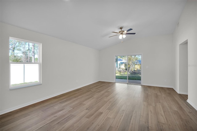 empty room with ceiling fan, light hardwood / wood-style floors, lofted ceiling, and a wealth of natural light