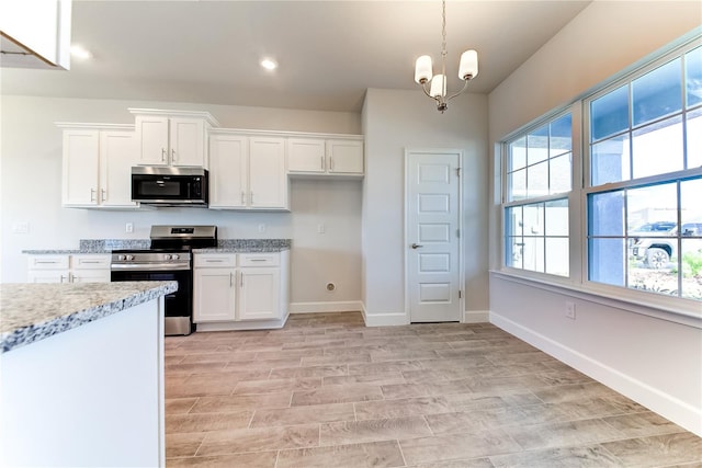 kitchen with stainless steel appliances, decorative light fixtures, light stone countertops, and white cabinets