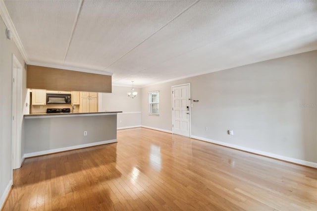 unfurnished living room with crown molding, light wood-type flooring, a notable chandelier, and baseboards