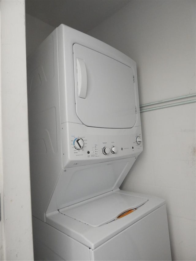 washroom featuring stacked washer and dryer and laundry area