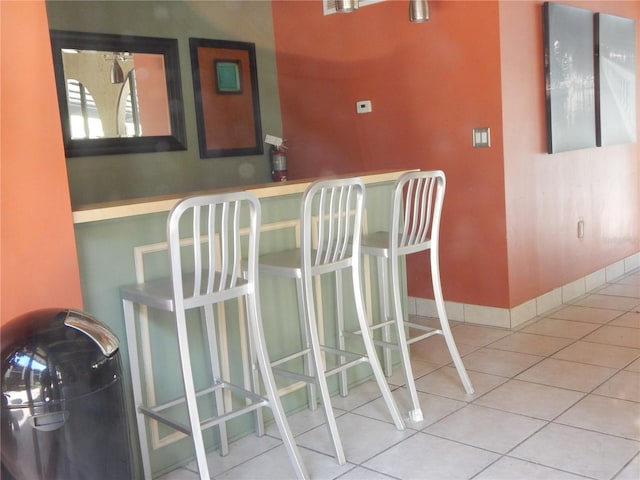 bar featuring baseboards and light tile patterned floors