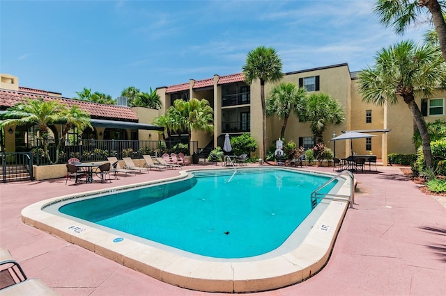 pool with a patio and fence