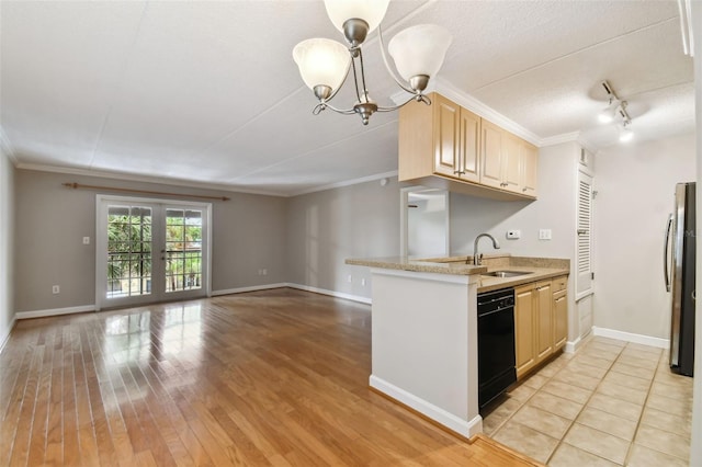 kitchen with light brown cabinets, a sink, black dishwasher, light countertops, and freestanding refrigerator