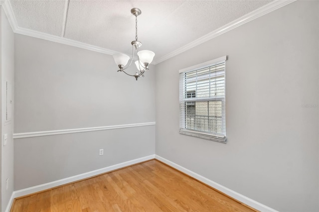 unfurnished room featuring crown molding, a textured ceiling, wood finished floors, and baseboards