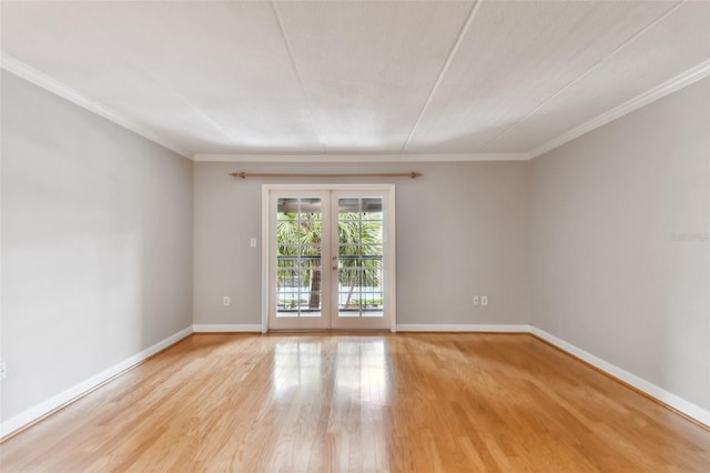 empty room featuring light wood finished floors, baseboards, ornamental molding, and french doors