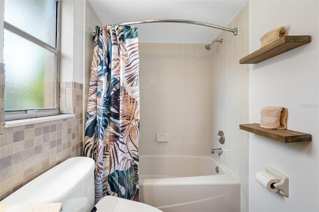 bathroom featuring tile walls, shower / bath combo, and toilet